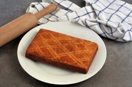 Pastel tradicional bretón en un plato con un rodillo y una toalla de té de cerca