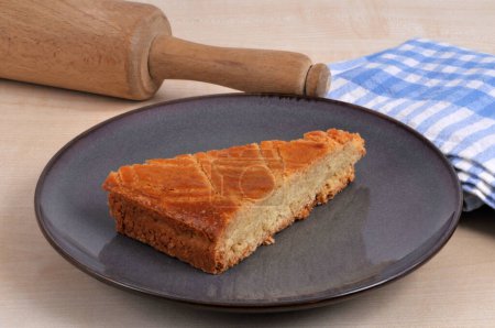Porción de pastel tradicional bretón en un plato con un rodillo y un primer plano de toalla de té