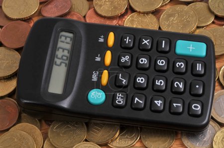 Téléchargez les photos : Calculatrice placée sur un fond de pièces en euros - en image libre de droit