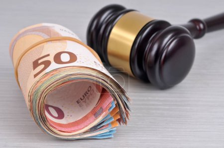 Roll of euro banknotes and judge gavel close-up