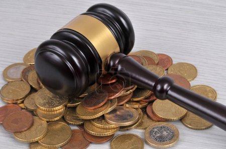 Judge gavel placed on loose euro coins 