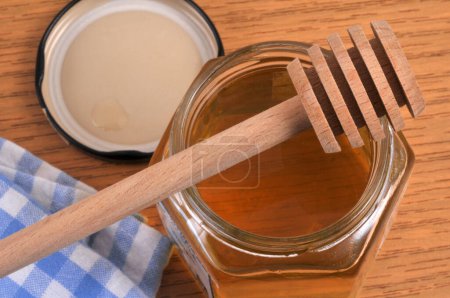 Foto de Cuchara de miel de madera colocada en una olla de miel - Imagen libre de derechos
