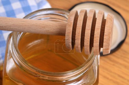 Foto de Cuchara de miel de madera colocada en una olla de miel - Imagen libre de derechos