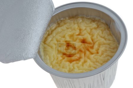 Aluminum pot of open industrial rice pudding seen from above on white background