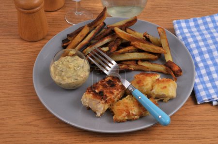 Teller mit hausgemachten Fish and Chips auf einem Tisch serviert