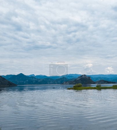 Foto de Vista del lago azul con el reflejo de árboles de hojas de aguja y montañas en montenegro - Imagen libre de derechos