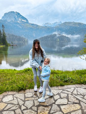 Téléchargez les photos : Mère joyeuse avec sa fille au beau lac du Monténégro, europe - en image libre de droit