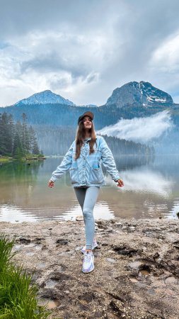 Foto de Mujer joven disfrutando de la belleza de la naturaleza mirando el lago de montaña en Montenegro - Imagen libre de derechos