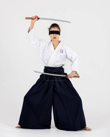 Photo for Aikido master woman in traditional samurai hakama kimono with black belt with sword, katana on white background. Healthy lifestyle and sports concept. - Royalty Free Image