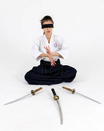 Téléchargez les photos : Maître Aïkido femme en kimono samouraï traditionnel hakama avec ceinture noire avec épée, katana sur fond blanc. Style de vie sain et concept sportif. - en image libre de droit