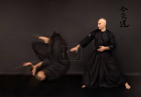 Téléchargez les photos : Portrait de maître aikido sensei avec ceinture sensei noire en kimono taekwondo sur fond noir. Kimono samouraï traditionnel hakama. Style de vie sain et concept sportif. - en image libre de droit