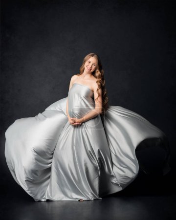 Téléchargez les photos : Femme enceinte sur fond noir avec gros ventre, attendant bébé. Grossesse, concept de maternité - en image libre de droit