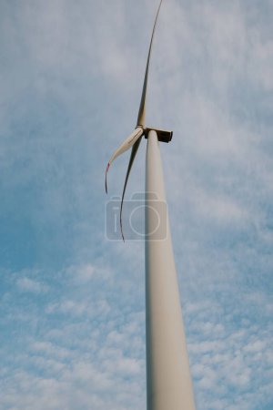 Foto de Molino de viento genera energía limpia. La turbina eólica produce energía renovable con hélice de origen natural contra el cielo azul - Imagen libre de derechos