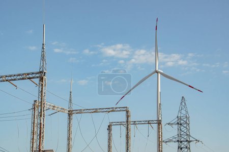 Foto de Molino de viento apoyar la subestación de distribución de electricidad. La turbina eólica ecológica produce energía para el funcionamiento de las líneas de transmisión de energía - Imagen libre de derechos