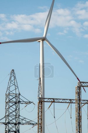 Téléchargez les photos : Moulin à vent prend en charge la sous-station de distribution d'électricité avec énergie. Les éoliennes utilisant des sources naturelles produisent des énergies renouvelables - en image libre de droit