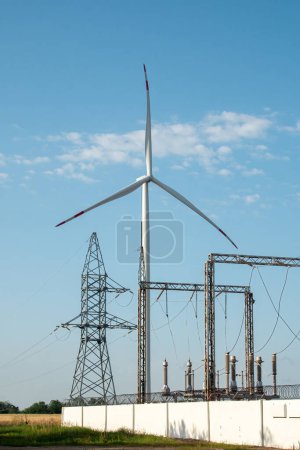 Photo for KYIV , UKRAINE - SEPTEMBER 27 2021: Wind turbine supports power on substation. Ecofriendly windmill produces renewable energy for supporting electricity distribution substation - Royalty Free Image