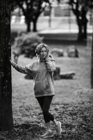 Photo for Woman wearing headphones exercising in the open air. Black and white photo. - Royalty Free Image