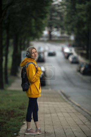 Photo for A woman wearing headphones goes for her morning workout. - Royalty Free Image