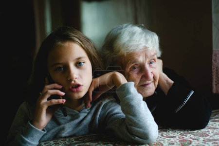 Oma hört Enkelin am Telefon zu.