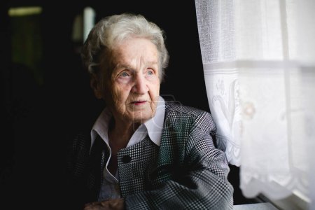 Retrato de una anciana en un elegante traje con un intrincado patrón tejido. 