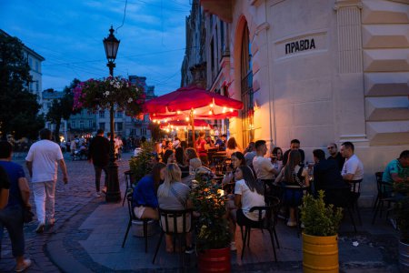 Foto de Lviv, Ucrania - 12 de julio de 2023: Gente en el restaurante al aire libre de Lviv. Teatro de la cerveza Pravda - Imagen libre de derechos