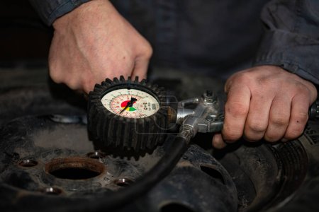 Foto de Neumático usado montaje e inflado primer plano en el servicio del coche - Imagen libre de derechos