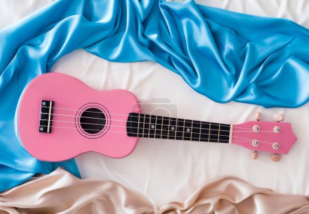 Photo for Pink ukulele on cloth background for design purpose - Royalty Free Image