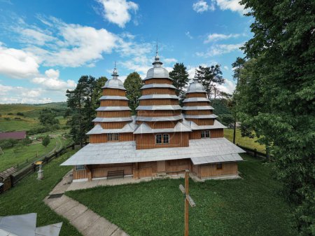 Photo for Matkiv, Ukraine - July 21, 2021: Aerial view on ancient wooden Church of Synaxis of the Holy Mother of God in Matkiv, Lviv region, Ukraine from drone - Royalty Free Image