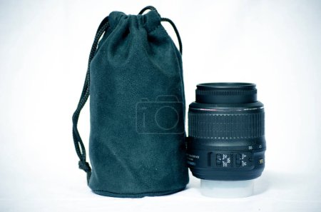Foto de Lente de cámara y bolsa sobre fondo blanco. Profundidad superficial del campo - Imagen libre de derechos