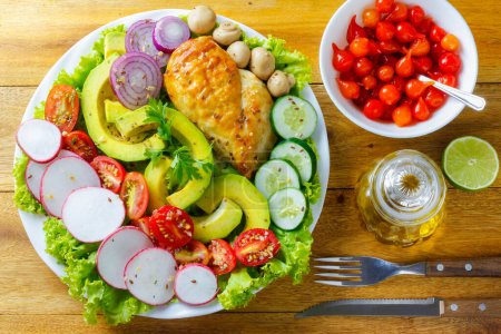 Téléchargez les photos : Salade de tomates, avocats, poulet, champignons, oignons, radis et chou-fleur crus frais. Concept d'aliments sains et désintoxiqués. Régime cétogène. salade verte. Vue du dessus - en image libre de droit
