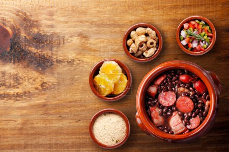 Téléchargez les photos : Feijoada brésilienne, cuisine traditionnelle brésilienne, sur un bol en céramique, sur une table en bois rustique. vue de dessus - en image libre de droit