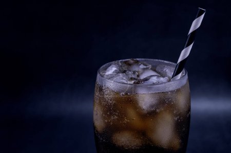Photo for Cool glass of cola drink with ice, bubbles and fizz. Fresh cold sweet with ice cubes. Cola glass with summer refreshment on black. - Royalty Free Image
