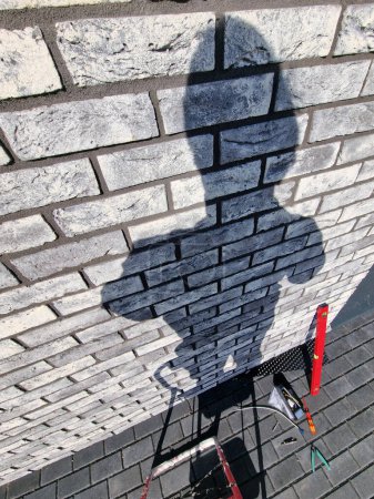 Photo for Shadow of electrician prepared to install wall exterior lighting - Royalty Free Image