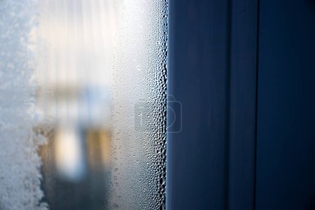 Téléchargez les photos : Fenêtre avec condensat ou vapeur après une forte pluie. fenêtres qui fuient dans la maison - en image libre de droit