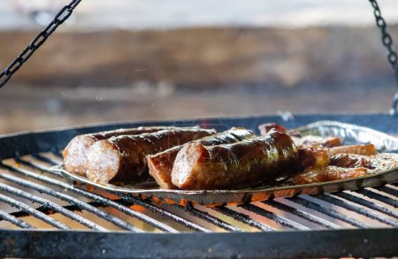Photo for "Savory sausage sizzling over campfire during a barbecue." - Royalty Free Image