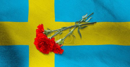 Téléchargez les photos : Image de trois oeillets rouges couchés sur le drapeau de la Suède - en image libre de droit