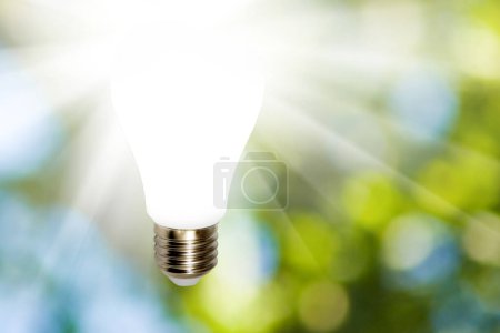 Photo for Image of a glowing light bulb on a green blurred background. The concept of the source of knowledge, ideas and reason - Royalty Free Image