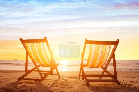 Strandtourismus, Urlaubshintergrund mit ein paar Liegestühlen bei Sonnenuntergang