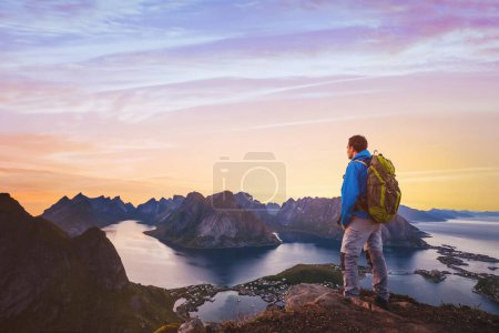 Foto de Viaje y aventura de fondo, excursionista con mochila disfrutando del paisaje del atardecer en Lofoten, Noruega - Imagen libre de derechos