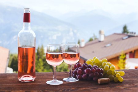 Foto de Botella de vino rosa con dos copas, cena romántica para pareja - Imagen libre de derechos