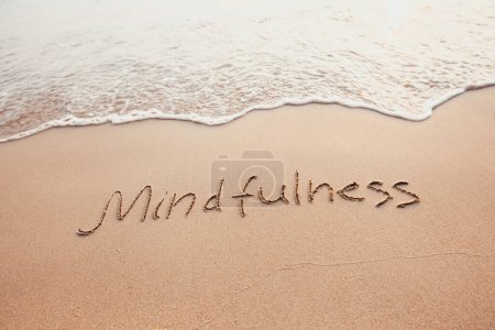 concepto de mindfulness, vida consciente, texto escrito en la arena de la playa