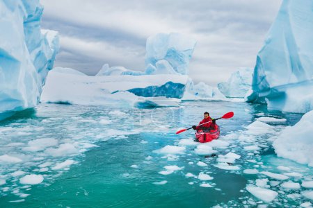 Foto per Turismo estremo, kayak invernale in Antartide, uomo avventuroso che remava sul kayak da mare tra gli iceberg - Immagine Royalty Free