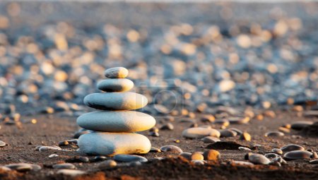 Zen-Steine am Strand, Balance von Harmonie und Frieden, Meditationskonzept im Sonnenuntergang