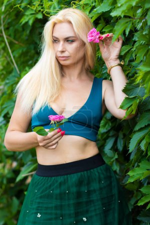 Photo for Beautiful fashion blonde model enjoying nature, breathing fresh air in summer garden over green leaves background. Harmony concept - Royalty Free Image