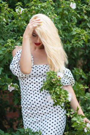 Téléchargez les photos : Garden Glamour : Femme blonde à pois ensemble - en image libre de droit