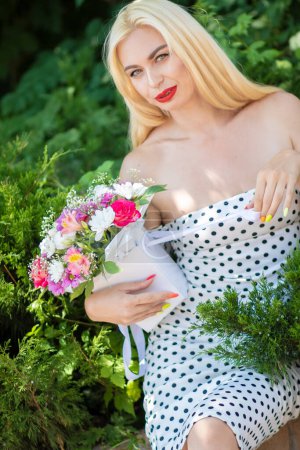 Photo for Polka Dot Blossom: Young Blonde Girl with Bouquet - Royalty Free Image