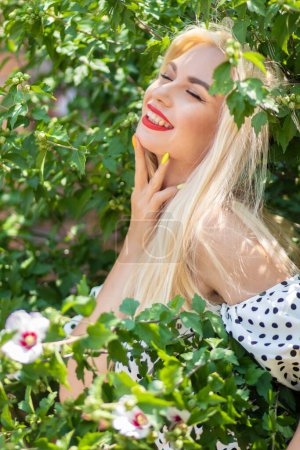 Photo for Garden Glamour: Blonde Woman in Polka Dot Ensemble - Royalty Free Image