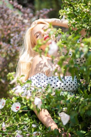 Foto de Glamour jardín: Mujer rubia en conjunto de lunares - Imagen libre de derechos