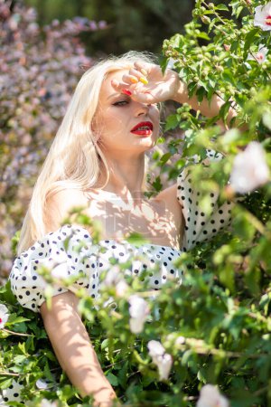 Foto de Glamour jardín: Mujer rubia en conjunto de lunares - Imagen libre de derechos