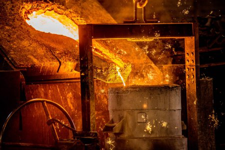 Téléchargez les photos : Un métallurgiste manipulant le feu avec du métal fondu - en image libre de droit